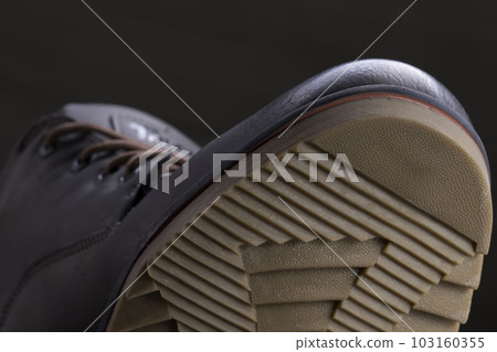 Part of a leather boot close-up. A fragment of the texture of a polyveritane sole. 103160355