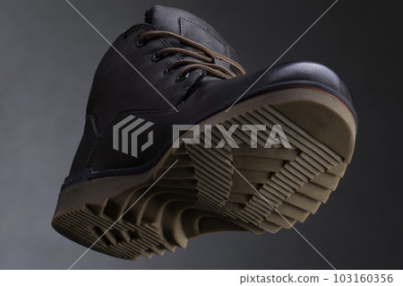 Leather boot on a dark background close-up view from below. Autumn shoes Leather boot on a dark background close-up view from below. Autumn shoes 103160356