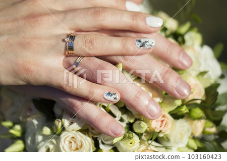Hands of the bride and groom on a wedding bouquet. Wedding day. 103160423