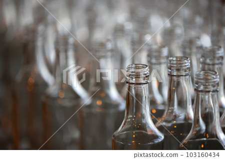 Glassworks. Glass industry. Many glass bottles on a factory conveyor. Glassworks. Glass industry. Many glass bottles on a factory conveyor. 103160434