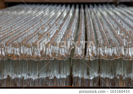 Glassworks. Glass industry. Many glass bottles on a factory conveyor in a row 103160435