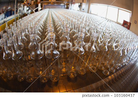 Glassworks. Glass industry. Many glass bottles on a factory conveyor. Glassworks. Glass industry. Many glass bottles on a factory conveyor. 103160437