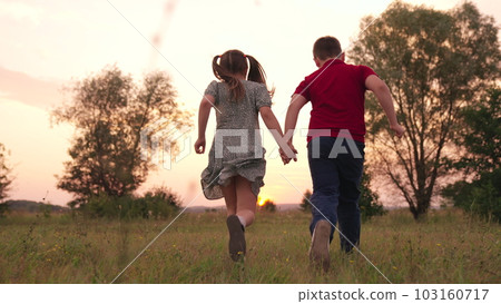 happy childhood, children legs green lawn, children run forest park sunset, children's legs run green grass park, childhood friendship concept, teamwork, hold hand, girl boy team, play sister brother 103160717