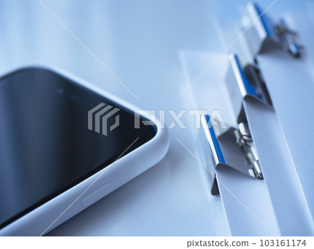 Documents and smartphones bound with clips on the table 103161174
