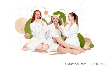 Three beautiful girls in bathrobe taking care after skin, applying organic face masks. Home spa procedure. Creative conceptual design. 103161592
