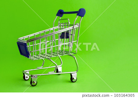Shopping cart on a green background. Shopping cart on a green background. 103164305