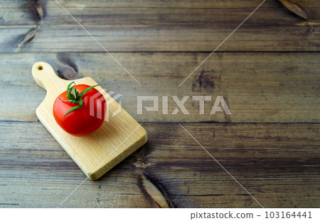 Tomato on a dark wooden table. Tomato on a dark wooden table. 103164441
