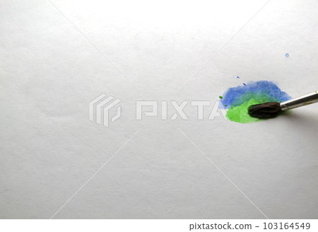 The brush draws blue and green watercolor paint. The brush draws blue and green watercolor paint. 103164549