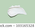 Liquid white cream smear isolated on green background. Beauty cosmetic smudge such as hair conditioner, creamy lotion, facial retinol serum, mask balm, cleanser, shower gel or shampoo top view 103165328
