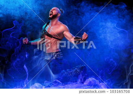 Handsome young sexy man with beautiful muscular chest in interesting costume on the scene 103165708