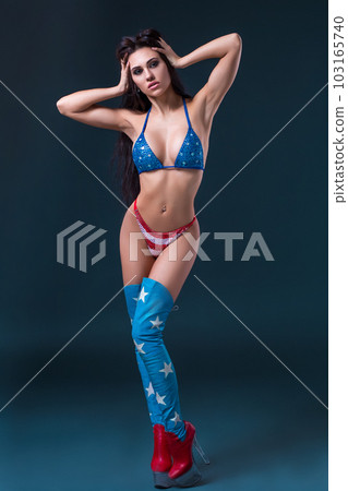 sexy young woman in erotic fetish wear dancing striptease in nightclub. Nude sexy woman in Show suit. 103165740