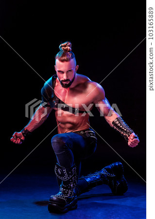 Handsome young sexy man with beautiful muscular chest in interesting costume on the scene Handsome young sexy man with beautiful muscular chest in interesting costume on the scene 103165889