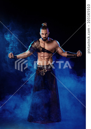Young and muscular man performing a theatrical pose on stage. Young and muscular man performing a theatrical pose on stage. 103165910