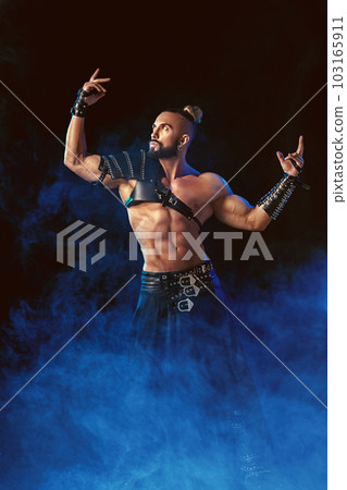 Young and muscular man performing a theatrical pose on stage. 103165911
