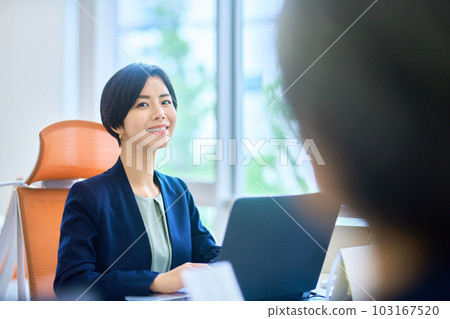 A business woman in a suit who works at the office desk A business woman in a suit who works at the office desk 103167520