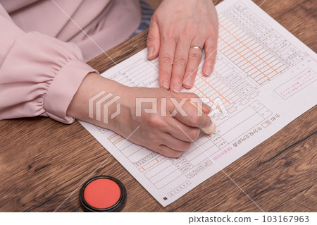 [Woman stamping the seal with vermilion] 103167963