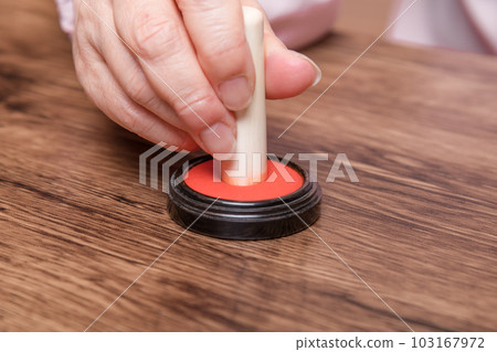 [Woman putting ink on seal] 103167972