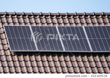 Photovoltaic solar panels mounted on residential house brown metallic tiles roof Photovoltaic solar panels mounted on residential house brown metallic tiles roof 103169538