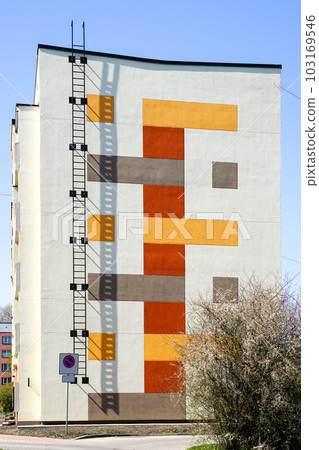 Renovated and insulated multistorey apartment building facade fragment against a blue sky background Renovated and insulated multistorey apartment building facade fragment against a blue sky background 103169546