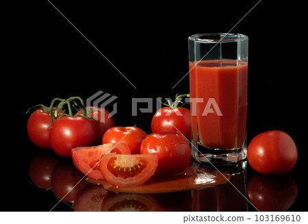 Fresh juicy tomatoes on a black background Fresh juicy tomatoes on a black background 103169610