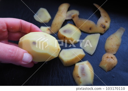 Fungal, viral or bacterial infection of the potato tuber. Dark spots inside the potato. Peeled raw potato with spots and a hole in a woman's hand. Food safety. The danger of farm natural products. Fungal, viral or bacterial infection of the potato tuber. Dark spots inside the potato. Peeled raw potato with spots and a hole in a woman's hand. Food safety. The danger of farm natural products. 103170110