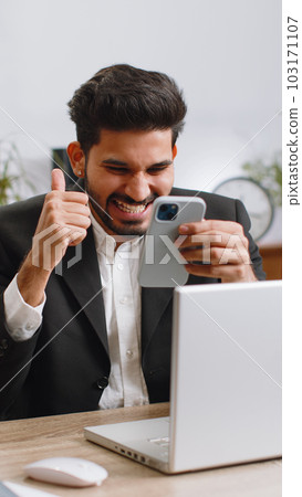 Businessman shocked by sudden victory on smartphone, game winning, lottery goal achievemen good news Businessman shocked by sudden victory on smartphone, game winning, lottery goal achievemen good news 103171107