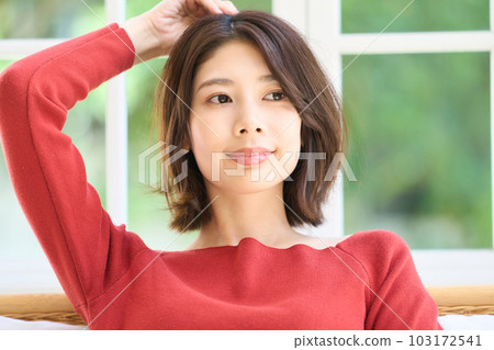 A young woman in plain clothes in the living room 103172541