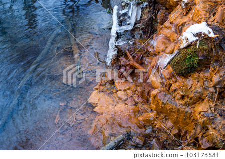 Output of mineral ferruginous springs, orange color of iron ocher Output of mineral ferruginous springs, orange color of iron ocher 103173881