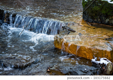 Small waterfalls on the river, limestone layers painted in orange with iron ochre 103173882