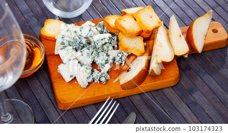 Roncari blue cheese with pear, toasts and honey on wooden board 103174323