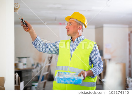 Repair man measuring evenness of wall 103174540