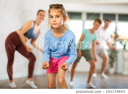 At home child learns to perform boogie-woogie figures with family 103174643