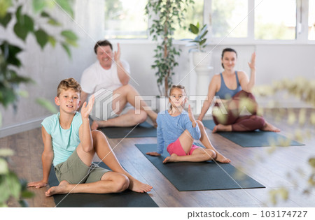Boy performs asana lord of fish for yoga class with his family 103174727