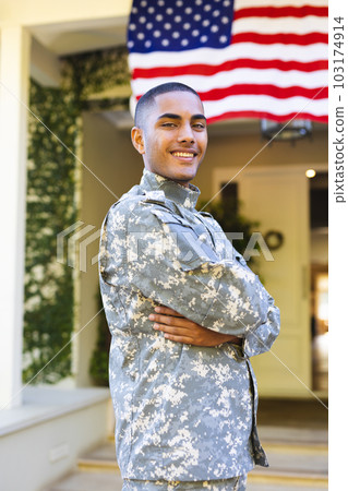 Portrait of happy biracial male american soldier wearing military uniform standing outside the house Portrait of happy biracial male american soldier wearing military uniform standing outside the house 103174914