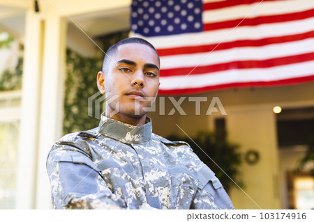 Portrait of biracial male american soldier wearing military uniform standing outside the house Portrait of biracial male american soldier wearing military uniform standing outside the house 103174916