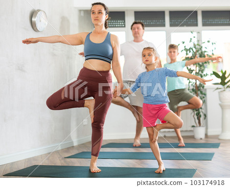 Parents help children to do pilates exercise in studio 103174918