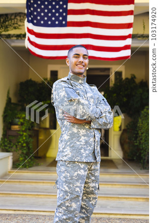 Portrait of happy biracial male american soldier wearing military uniform standing outside the house Portrait of happy biracial male american soldier wearing military uniform standing outside the house 103174920
