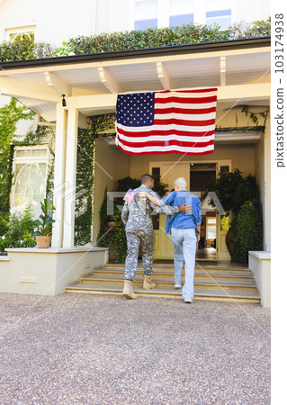 Happy caucasian woman and biracial male american soldier embracing outside the house Happy caucasian woman and biracial male american soldier embracing outside the house 103174938