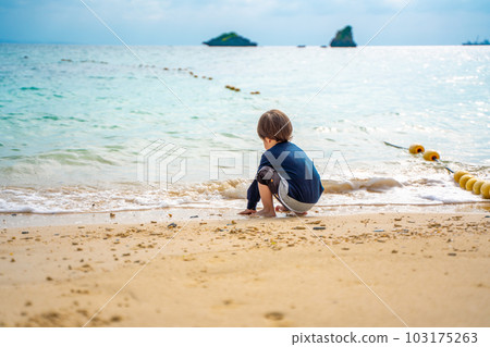 A boy who enjoys playing in the water in the sea in early summer A boy who enjoys playing in the water in the sea in early summer 103175263