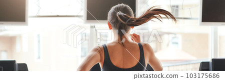 Fast and strong. Back view of young and sporty woman in sportswear is running on a high speed on a treadmill at gym. Cardio workout. Fast and strong. Back view of young and sporty woman in sportswear is running on a high speed on a treadmill at gym. Cardio workout. 103175686