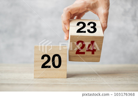 hand flipping block 2023 to 2024 text on table. Resolution, strategy, plan, goal, motivation, reboot, business and New Year holiday concepts hand flipping block 2023 to 2024 text on table. Resolution, strategy, plan, goal, motivation, reboot, business and New Year holiday concepts 103176368