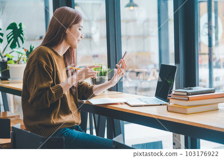 young student wearing headphones studies online, distance learning, and keeps up to date on the global coronavirus pandemic.. 103176922