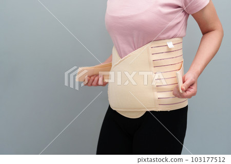 woman wearing lumbar support belts. pregnant and postnatal lumbar brace woman wearing lumbar support belts. pregnant and postnatal lumbar brace 103177512