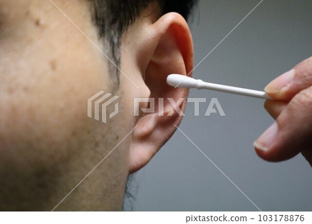Ear cleaning with a cotton swab 103178876