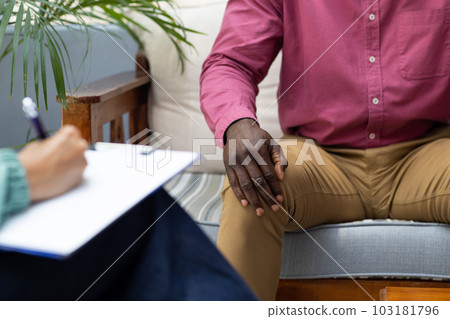Midsection of african american male patient attending therapy with therapist 103181796