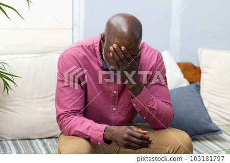 Worried african american male patient sitting on sofa attending therapy with therapist 103181797