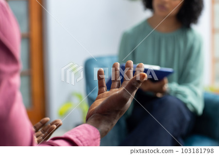 Midsection of african american male patient attending therapy with biracial female therapist 103181798