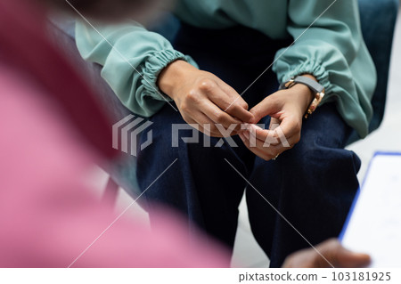 Midsection of biracial female patient attending therapy with african american male therapist 103181925