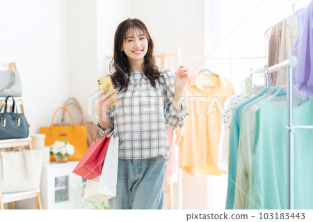 Young woman operating a smartphone while shopping in a shopping center Young woman operating a smartphone while shopping in a shopping center 103183443