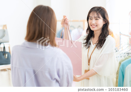 Young female clerk working in an apparel shop Young female clerk working in an apparel shop 103183460